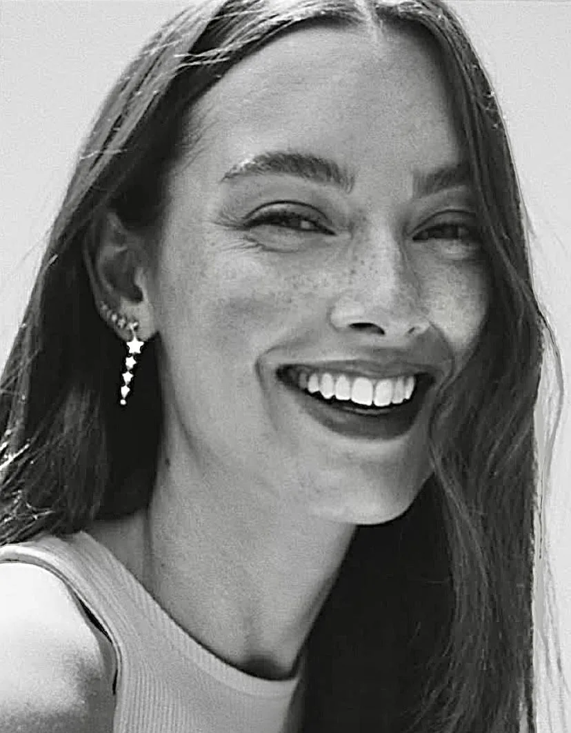 Black-and-white editorial close-up of a smiling woman